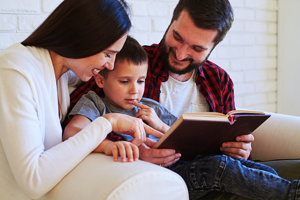 Couple reading to their son.